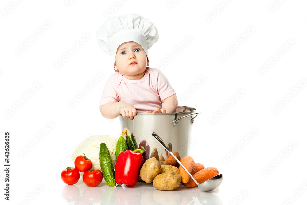 Little girl in the cap chef chef pot with vegetables and a pork chop Little girl in the cap chef chef pot with vegetables and a pork chop