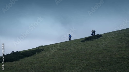 Hikers Walk Down Hillside