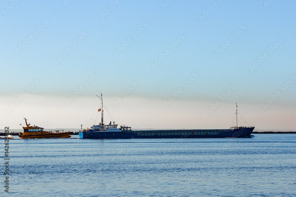 Blue cargo ship leaving Riga and entering Baltic sea