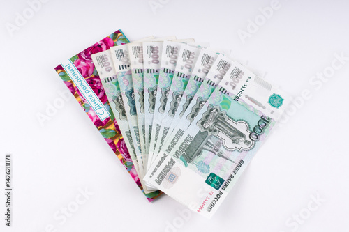 A stack of thousand-ruble banknotes, spread out and an envelope for money. Russian currency on a white background.
