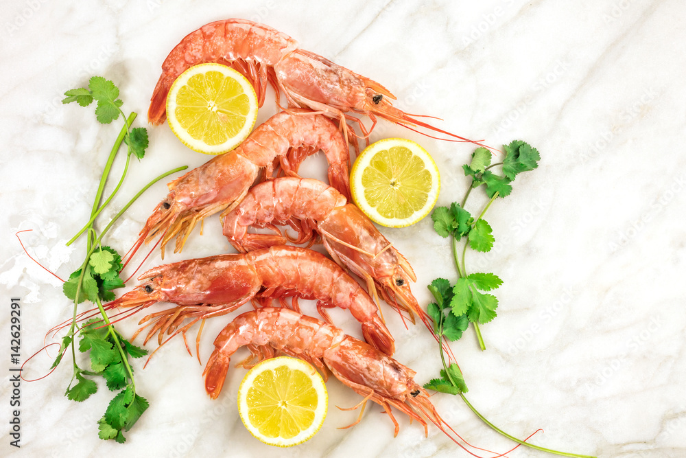 Raw shrimps with slices of lemon, cilantro, and copyspace Raw shrimps with slices of lemon, cilantro, and copyspace