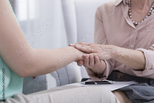 Psychologist holding her patient s hand