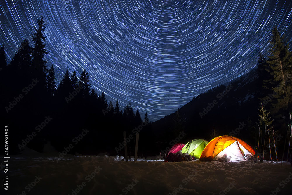 Night camp with illuminated tents in the mountain landscape with star trails  in the sky Stock Photo | Adobe Stock