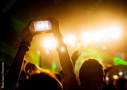 People recording with smart phones concert crowd music festival.