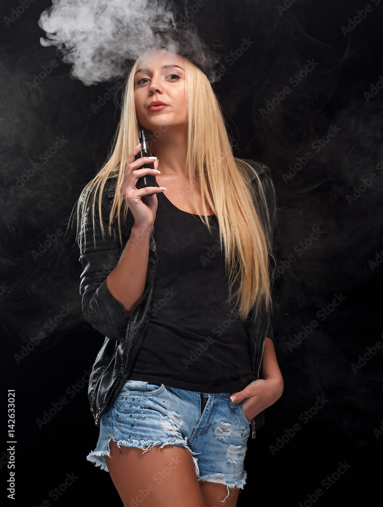 Fototapeta premium Young sexy blond woman is vaping.