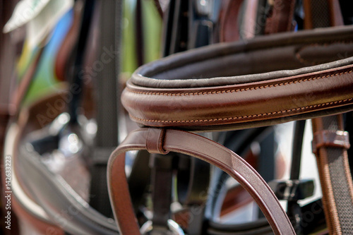 Close up of horse bridles on the display rack