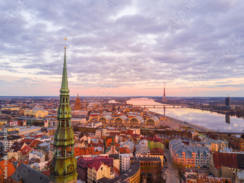 Beautiful pink aerial sunset view of Riga town from above. Amazing sky. Beautiful nature. St. Peters cathedral in the foreground.