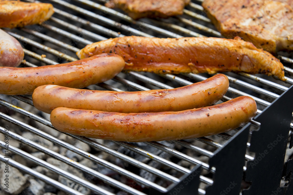 Fleisch und Wurst werden auf einem Grill zubereitet Fleisch und Wurst werden auf einem Grill zubereitet