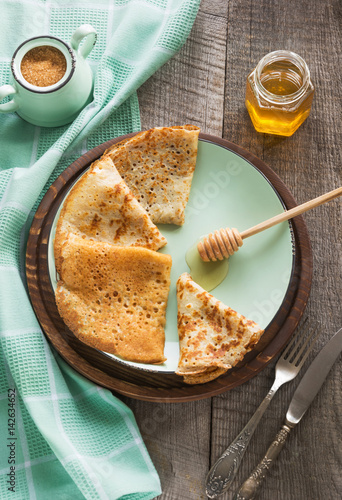 Photography Tasty traditional russian breakfast of slapjack with honey on plate