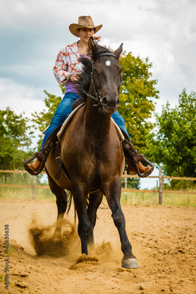 Cowgirl doing horse riding on countryside meadow Cowgirl doing horse riding on countryside meadow