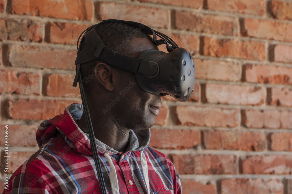 Obraz premium Man wearing virtual reality device. Headset. Glasses with virtual screen. Young man touch something using modern glasses with virtual screen.