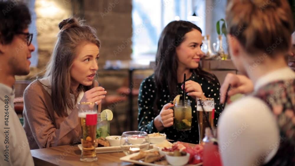 happy friends eating and drinking at bar or cafe happy friends eating and drinking at bar or cafe