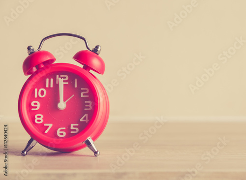 Retro alarm clock on a table. Photo in retro color image style