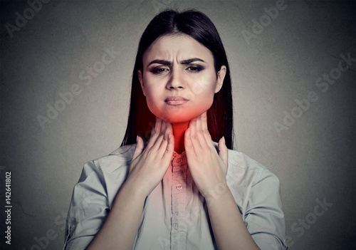 Принти на полотні Woman with sore throat touching her neck colored in red