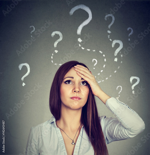 Bilde på lerret Woman with worried expression looking up has many questions
