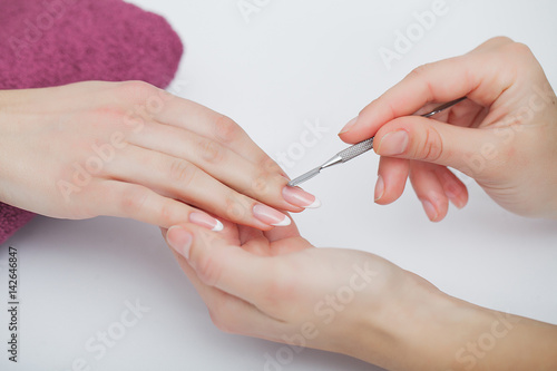 Woman Hand Care. Closeup Of Beautiful Female Hands Having Spa Manicure At Beauty Salon. Beautician Filing Clients Healthy Natural Nails With Nail File. Nail Treatment. High Resolution