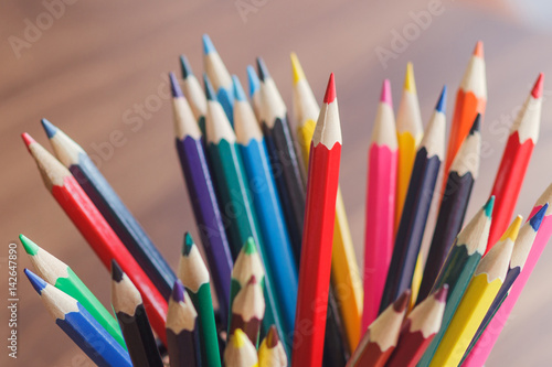 Set of colored pencilsin the glass, wooden background