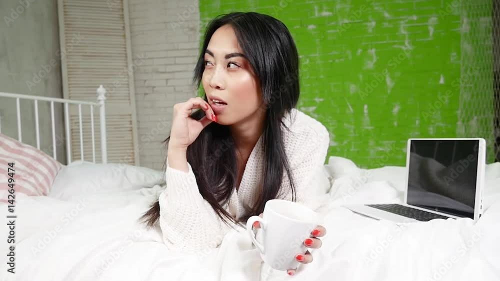 Beautiful young asian girl relaxing in bed. Beautiful young asian girl relaxing in bed.