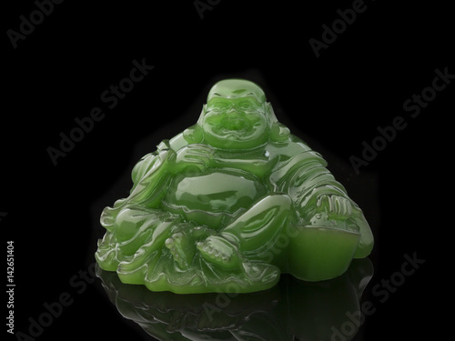 Buddha statue made of green jade on a black background