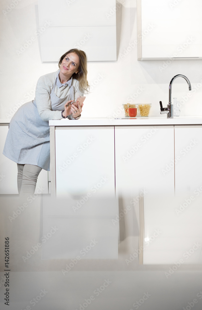 Happy young woman cooking in the kitchen at home Happy young woman cooking in the kitchen at home