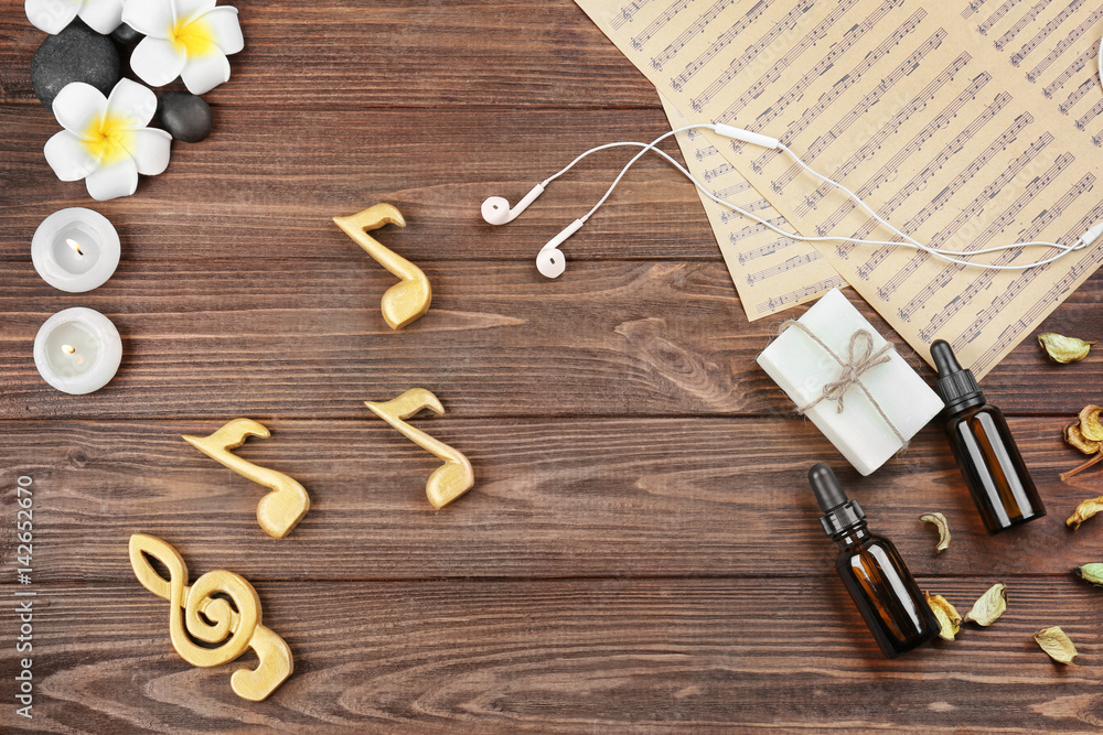 Composition of music sheets and spa supplies on wooden background Composition of music sheets and spa supplies on wooden background