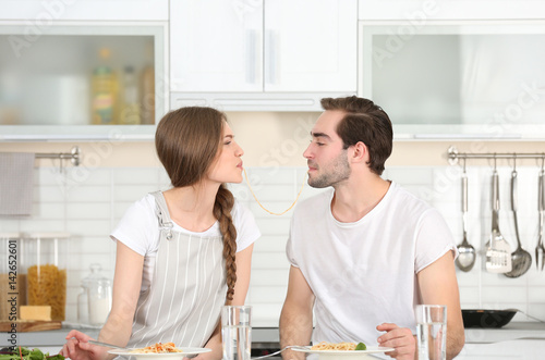 Young couple eating pasta o...