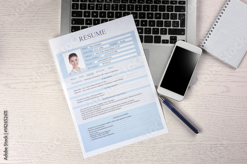 Resume, phone and laptop on...