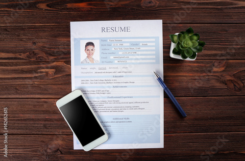 Resume and phone on wooden ...