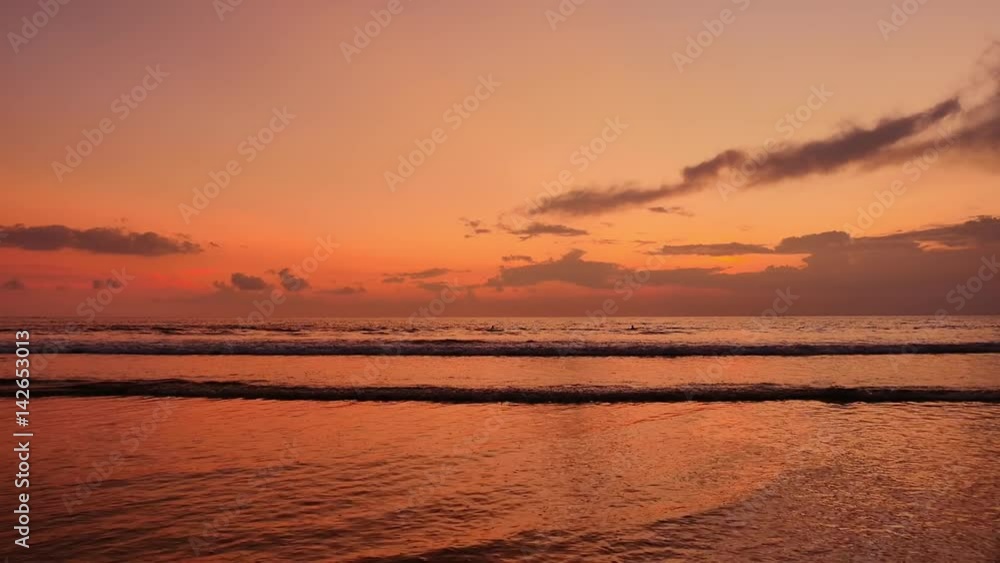 Slow motion of sea waves roll on coast of Bali island at orange sunset time Slow motion of sea waves roll on coast of Bali island at orange sunset time