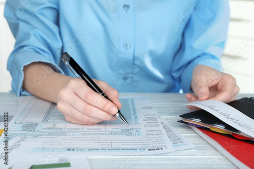 Woman filling form of Individual Income Tax Return, closeup photo