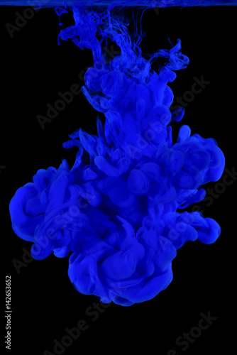 blue cloud acrylic paint in water isolated on black background.