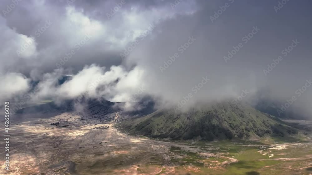 Dramatic timelapse of fast moving clouds over Bromo volcano in Java, Indonesia. Extreme harsh nature landscape beautiful background Dramatic timelapse of fast moving clouds over Bromo volcano in Java, Indonesia. Extreme harsh nature landscape beautiful background