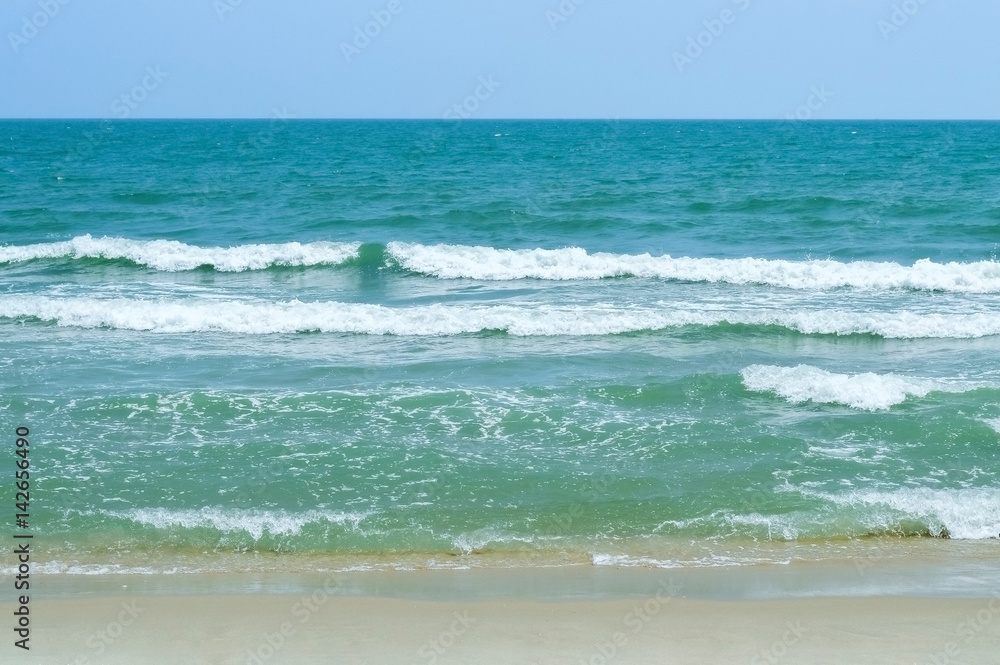Waves in the ocean and sand on the beach