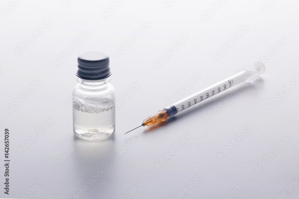 Substance abuse!. One syringe and a mysterious vial on a white table. Self-medication. Health danger. Substance abuse!. One syringe and a mysterious vial on a white table. Self-medication. Health danger.