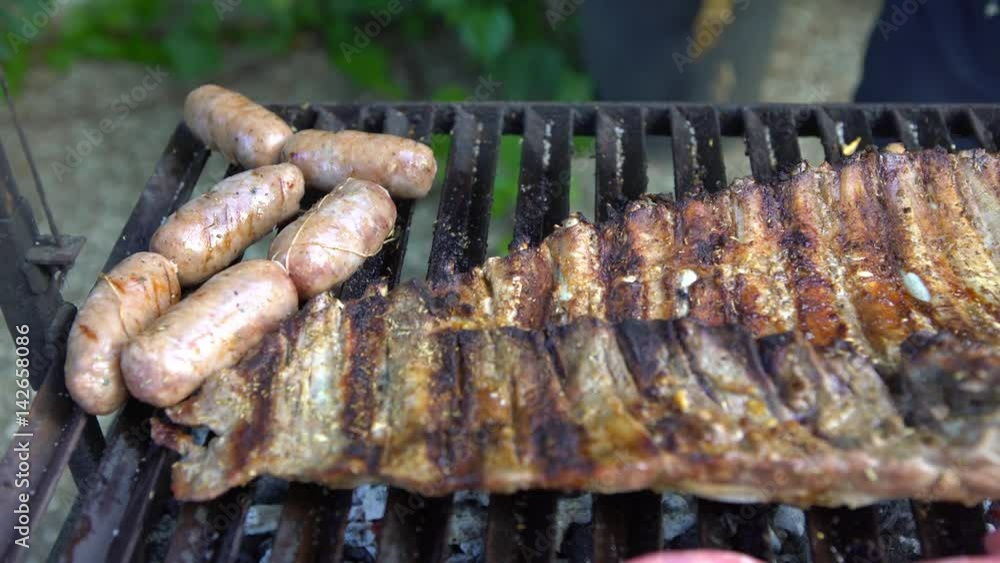 4K Cooking barbecue with delicious grilled meat. Unhealthy fatty BBQ of Ribs Pork and Sausages, spanish chorizo, Chistorra, Morcilla, Blood sausage being fried on a charcoal grill -Dan 4K Cooking barbecue with delicious grilled meat. Unhealthy fatty BBQ of Ribs Pork and Sausages, spanish chorizo, Chistorra, Morcilla, Blood sausage being fried on a charcoal grill -Dan