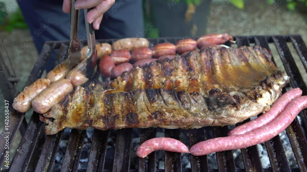 4K Cooking barbecue with delicious sauce on grilled meat. Unhealthy fatty BBQ of Ribs Pork and Sausages, spanish chorizo, Chistorra, Morcilla, Blood sausage being fried on a charcoal grill -Dan 4K Cooking barbecue with delicious sauce on grilled meat. Unhealthy fatty BBQ of Ribs Pork and Sausages, spanish chorizo, Chistorra, Morcilla, Blood sausage being fried on a charcoal grill -Dan