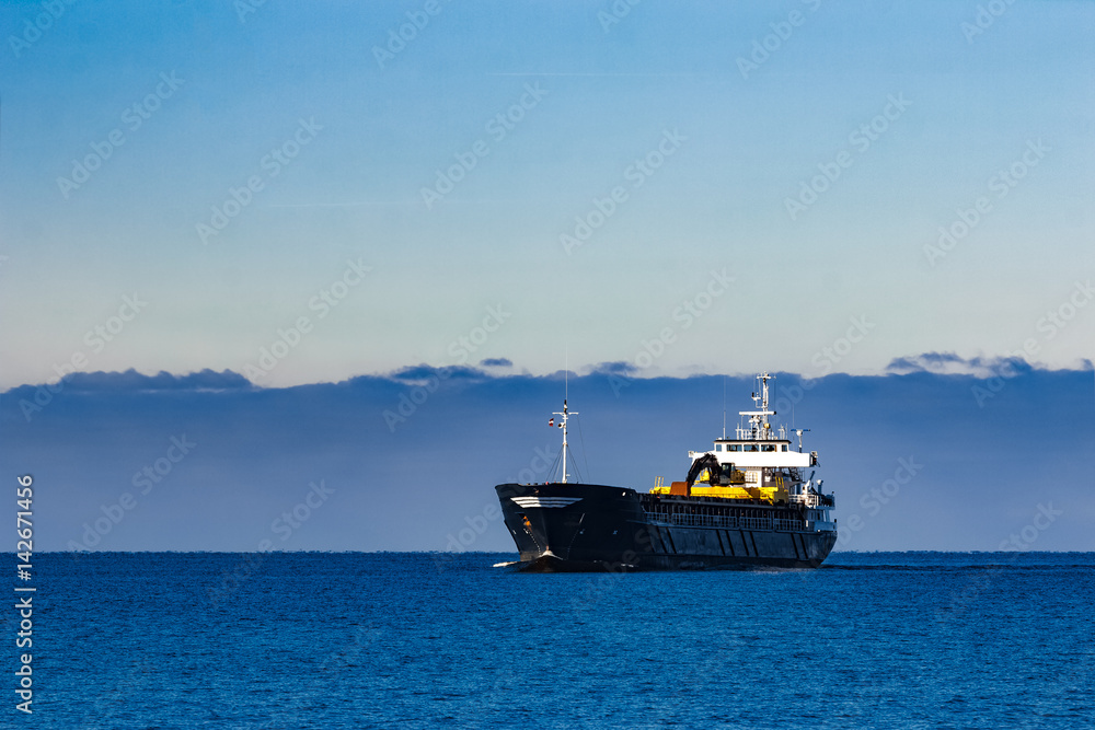 Black cargo ship with long reach excavator moving by baltic sea Black cargo ship with long reach excavator moving by baltic sea