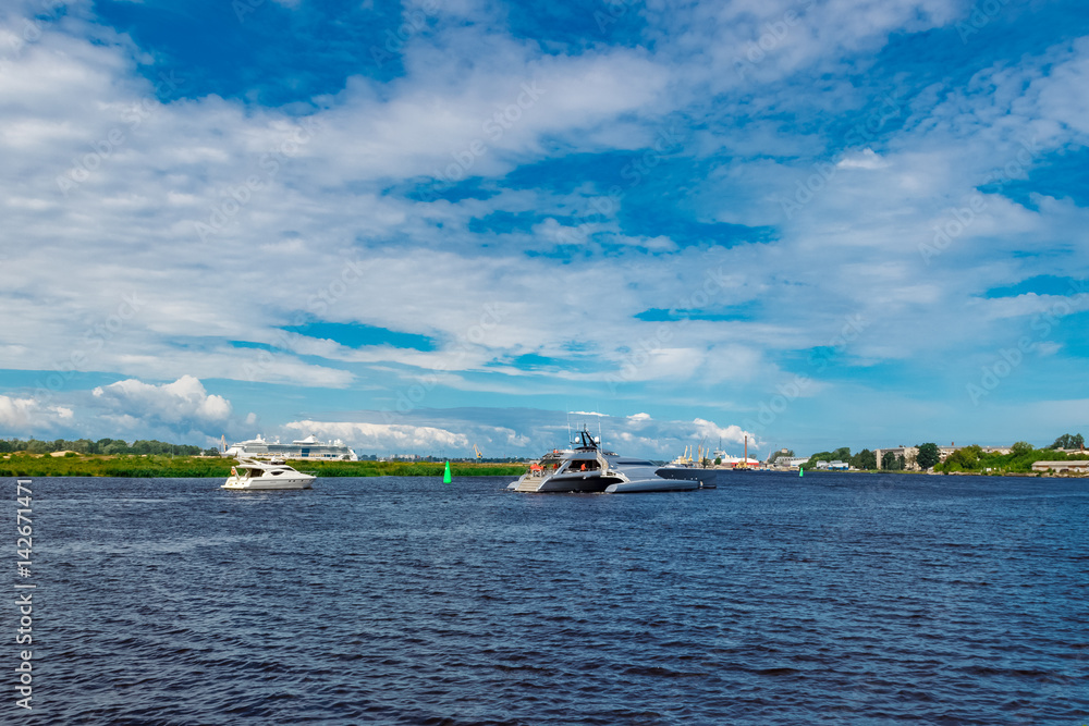 Large silver trimaran. Luxury yacht sailing by the river in Riga