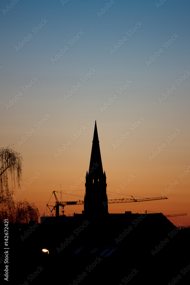 Obraz premium Sunset silhouette, church and crane