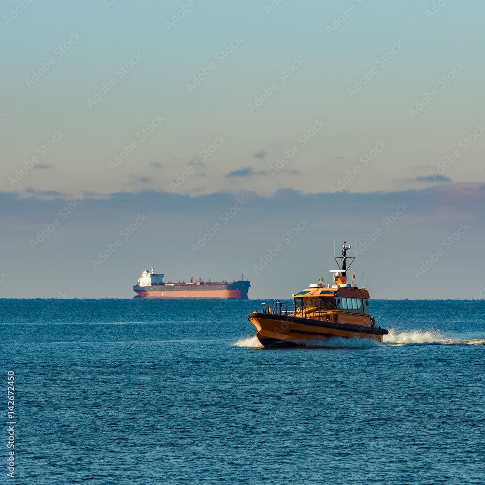 Fototapeta premium Yellow pilot ship moving at speed from the Baltic sea