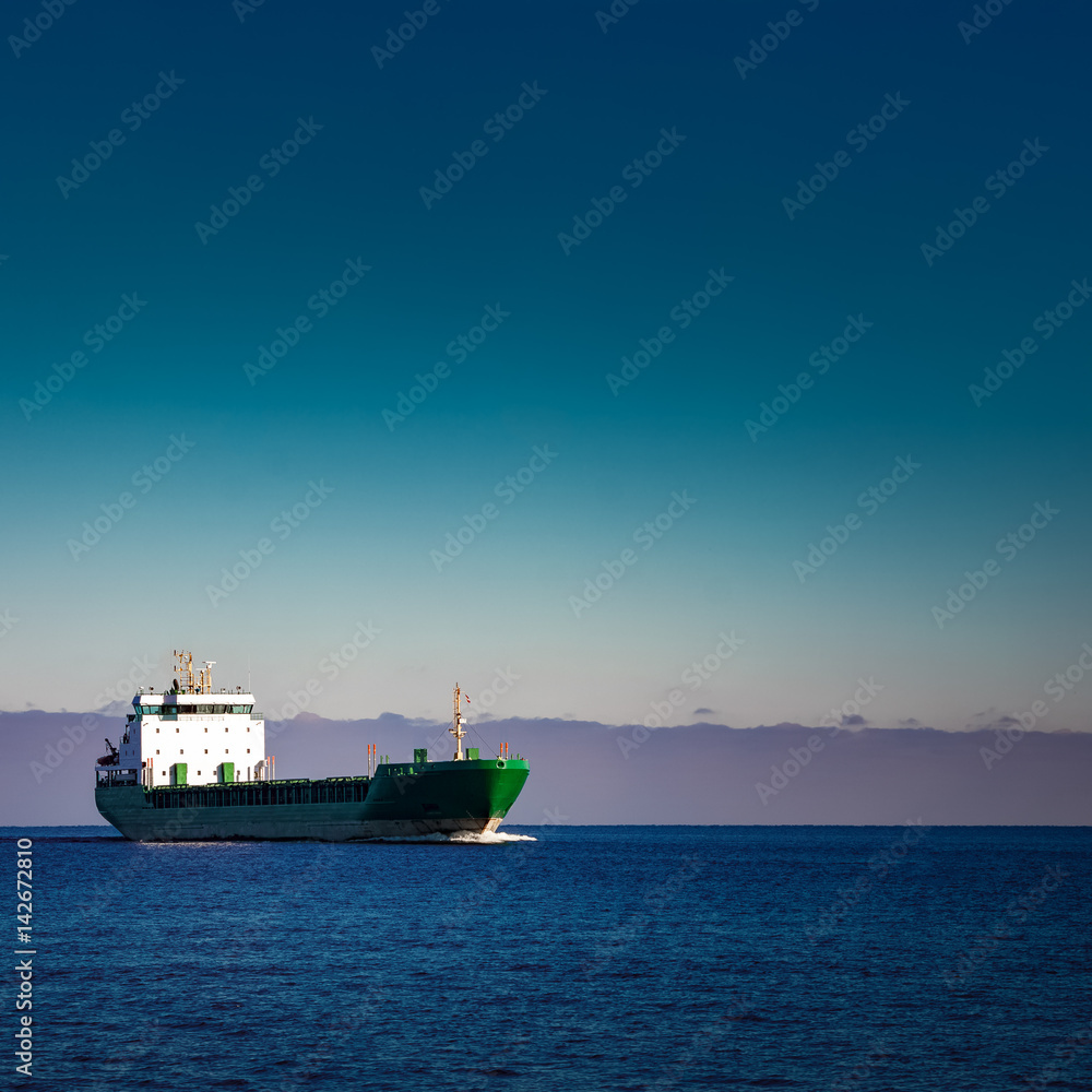 Green cargo ship moving in still water of Baltic sea