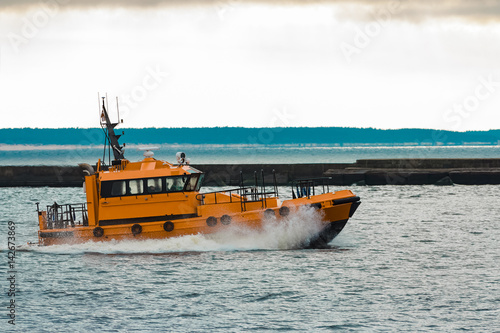 Orange pilot ship moving fast in Baltic sea