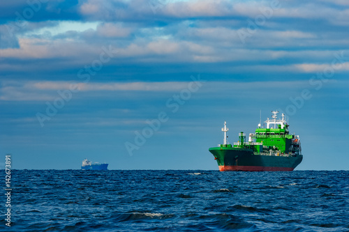 Green cargo ship moored in still Baltic sea water