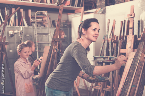 Students working patiently during painting class at art studio