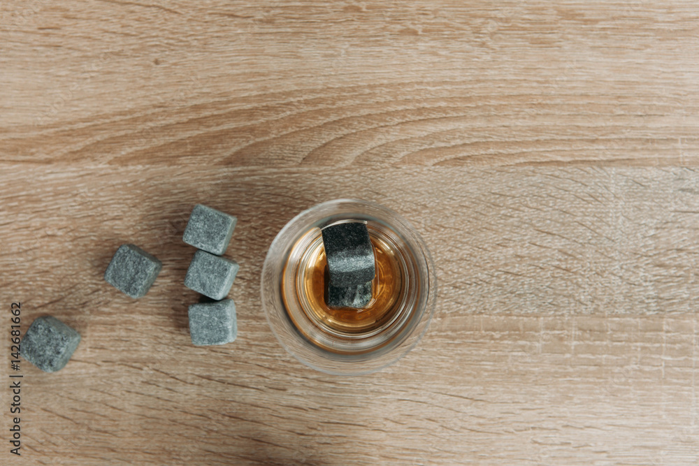 Stones for cooling whiskey and glases tulup on light wooden background Stones for cooling whiskey and glases tulup on light wooden background
