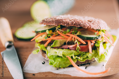 Vegetarian sandwich with lettuce, cucumber, carrot tomato anda avocado photo