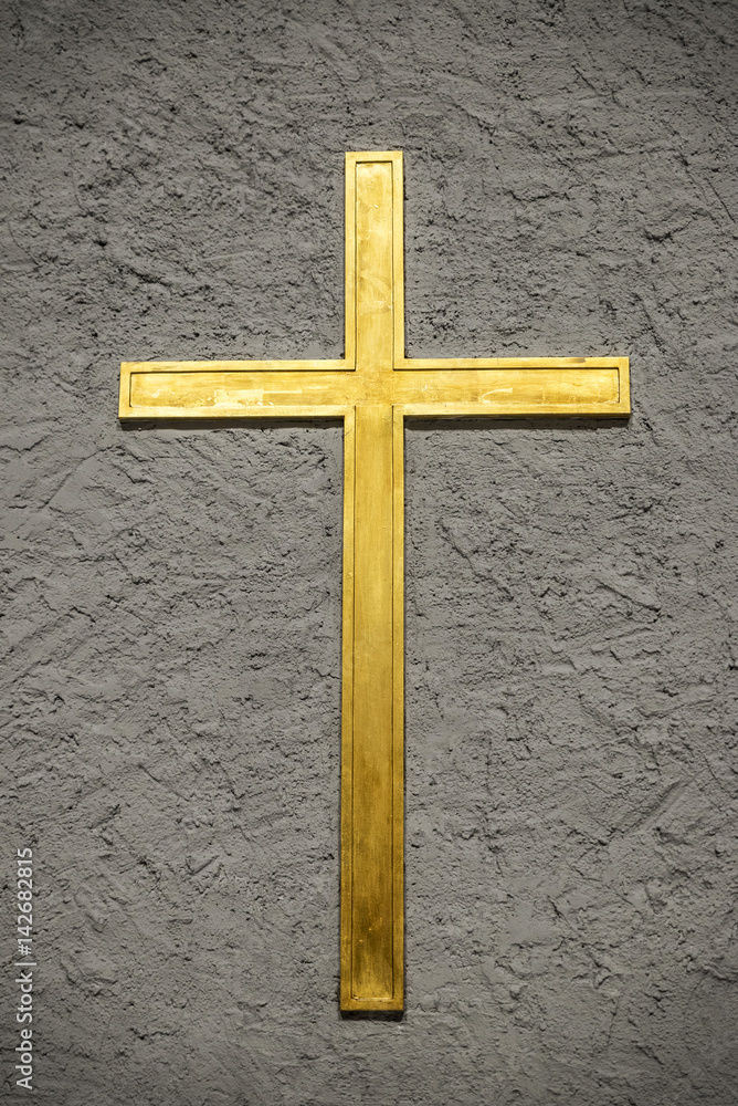 Christian golden cross on a wall in a church