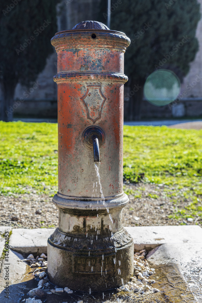 Old metal fountain with open faucet Old metal fountain with open faucet