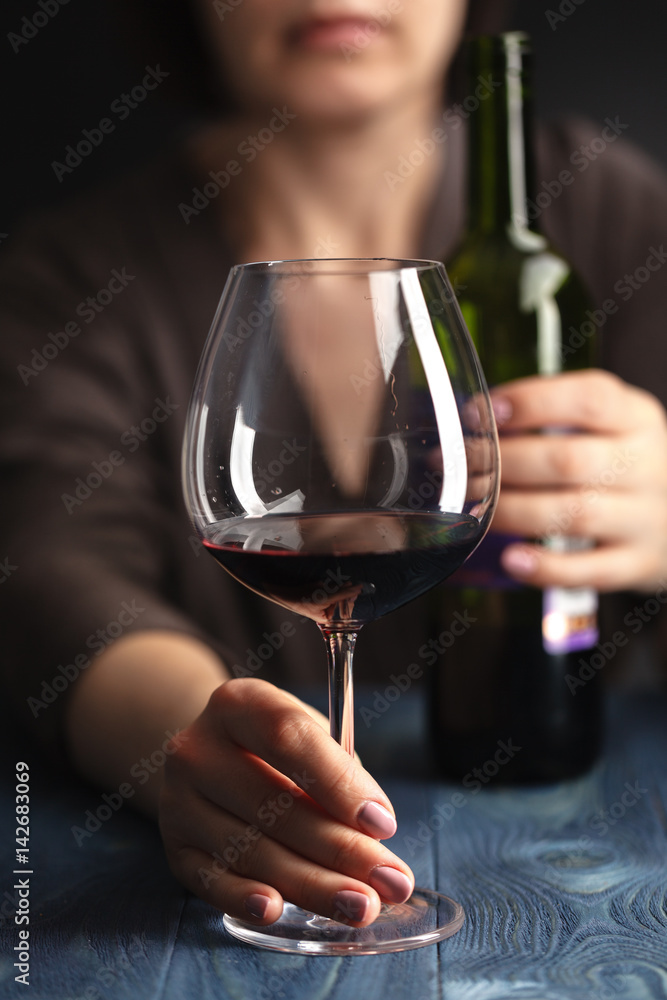 sad and wasted alcoholic woman sitting at home drinking red wine holding glass,  alcohol abuse