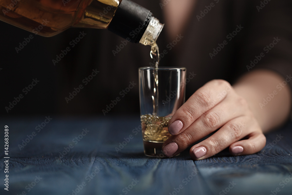 Female pouring whiskey in to glass shot Female pouring whiskey in to glass shot